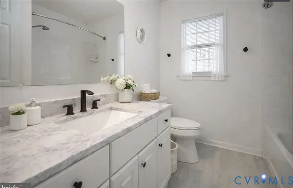 a bathroom with a granite countertop toilet sink and mirror