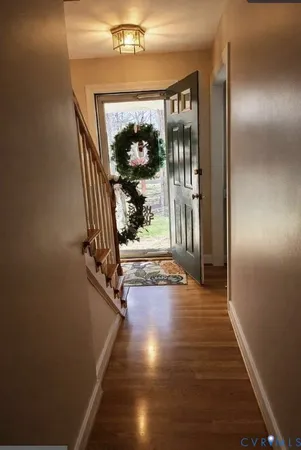 a view of a hallway with wooden floor and entryway