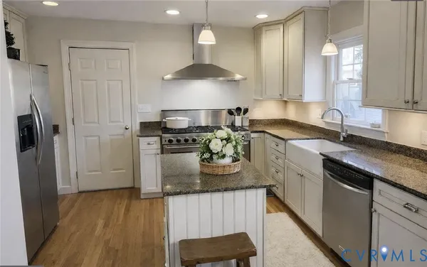 a kitchen with stainless steel appliances granite countertop a sink stove and refrigerator