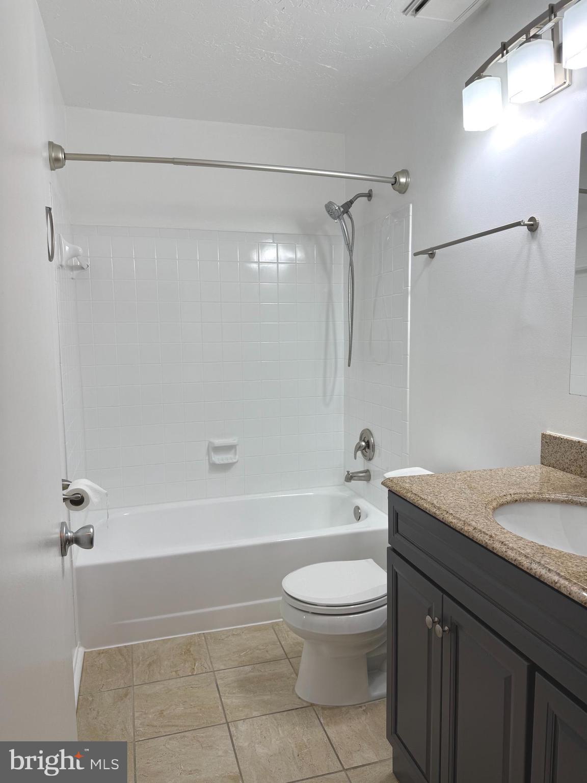 11743 Summerchase Circle, Unit B Reston, VA 20194 - Photo 12 of 25 a bathroom with a granite countertop bathtub shower sink vanity and toilet