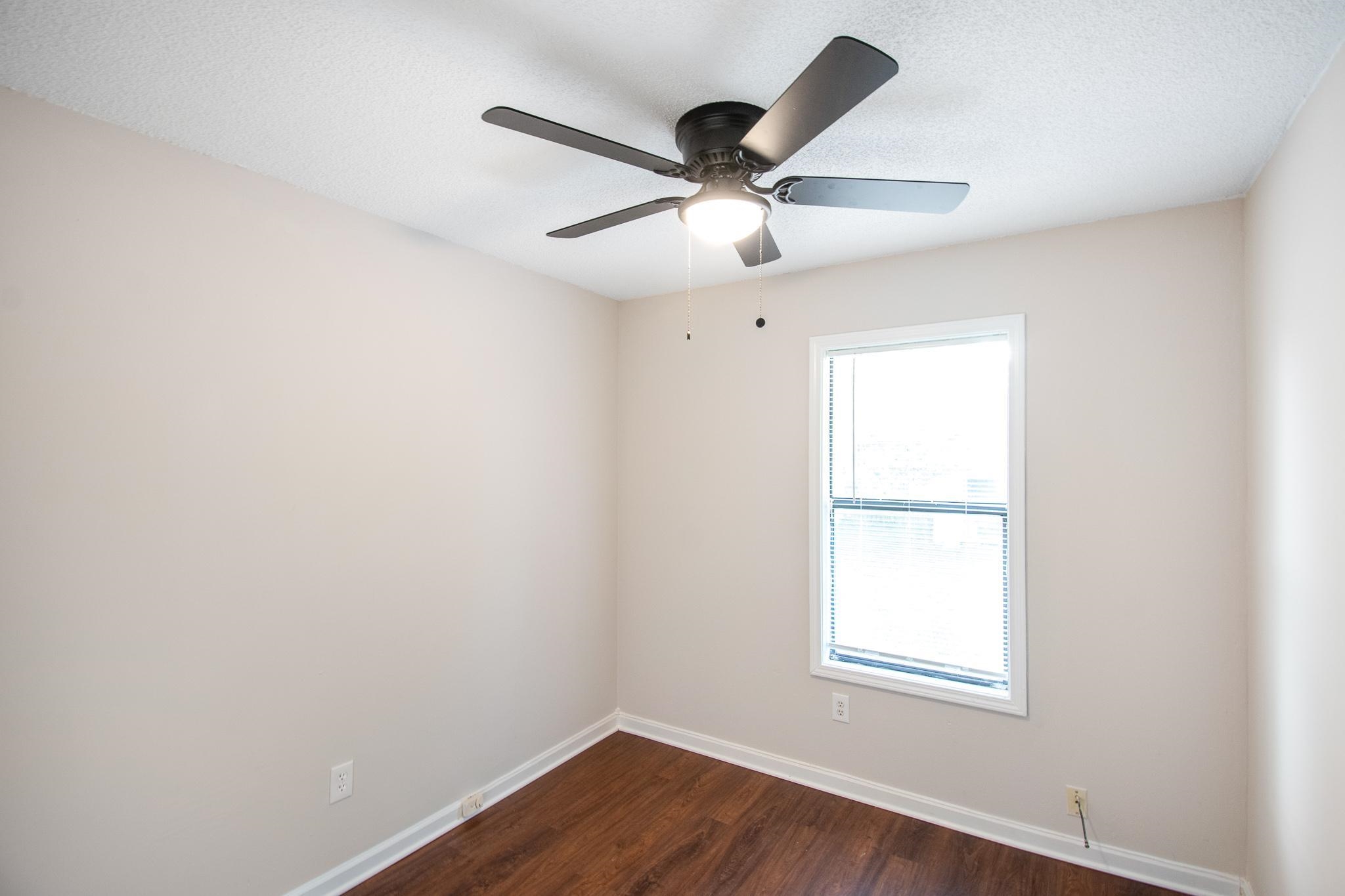 4775 Allrand Road Memphis, TN 38118 - Photo 17 of 21 an empty room with wooden floor ceiling fan and window