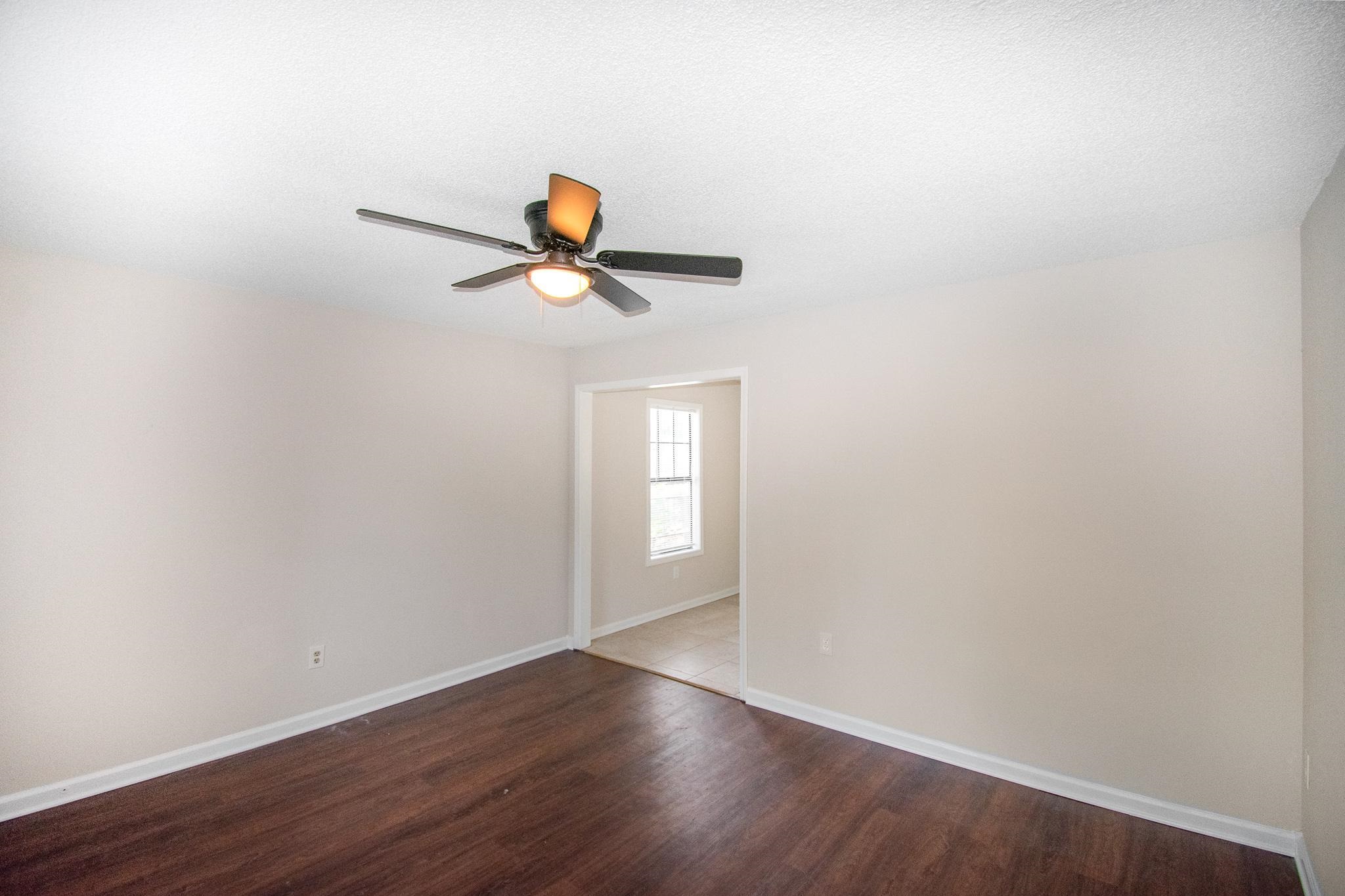 4775 Allrand Road Memphis, TN 38118 - Photo 6 of 21 an empty room with wooden floor and windows