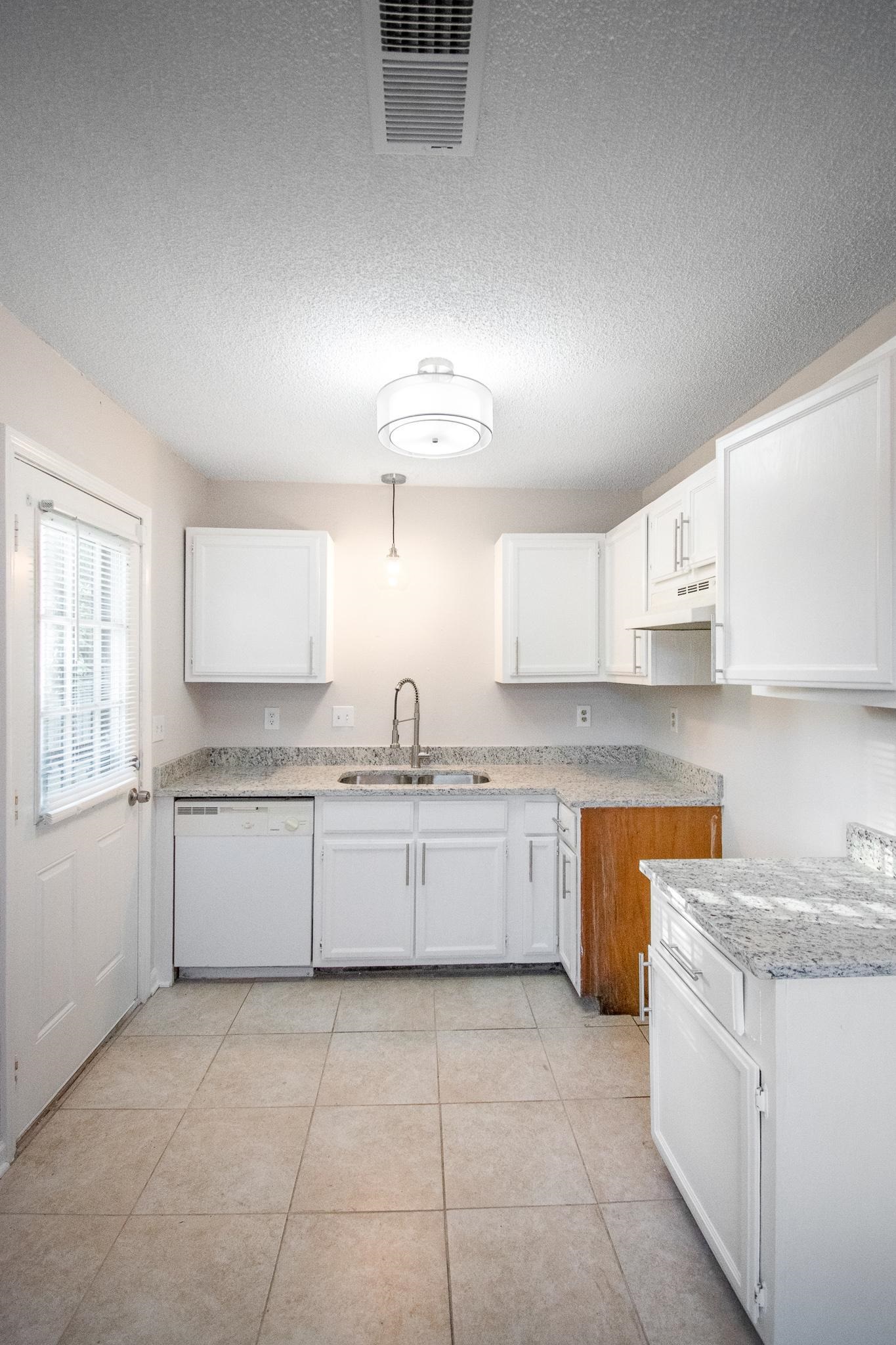 4775 Allrand Road Memphis, TN 38118 - Photo 8 of 21 a kitchen with granite countertop a sink a stove top oven a counter space and cabinets