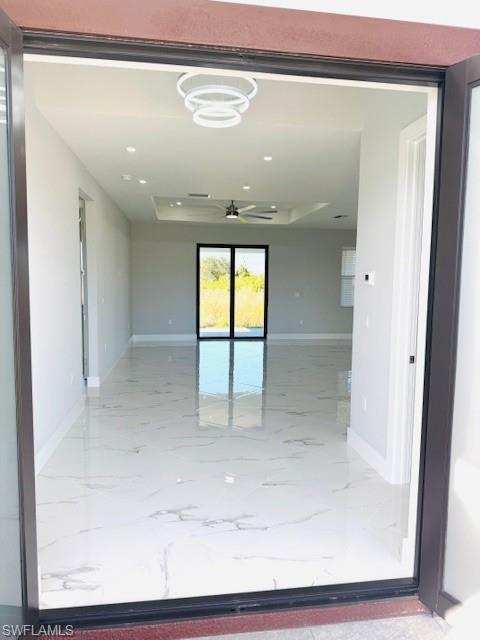 165 Patio Street Lehigh Acres, FL 33974 - Photo 12 of 34 Spare room with recessed lighting, a tray ceiling, ceiling fan, and light marble finish floors