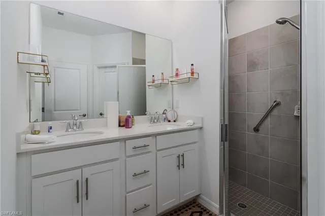 a bathroom with a double vanity sink a mirror and a shower
