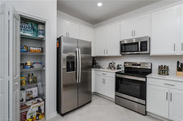 a kitchen with stainless steel appliances granite countertop a refrigerator and a stove top oven