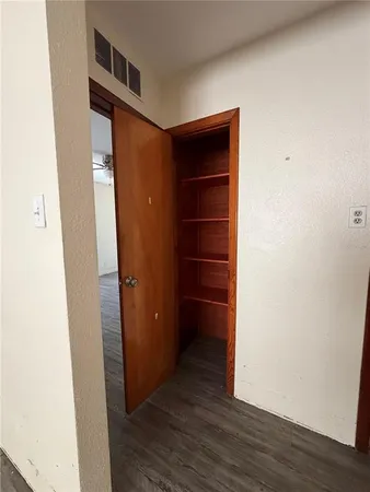 a view of walk in closet with wooden floor