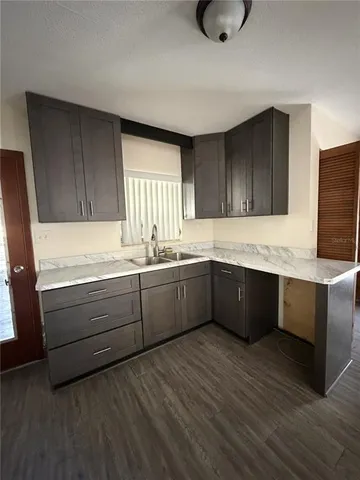 a kitchen with granite countertop wooden cabinets a sink and dishwasher
