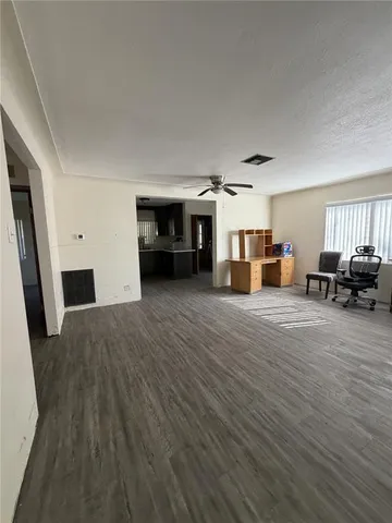 a view of a livingroom with furniture hardwood floor and a ceiling fan