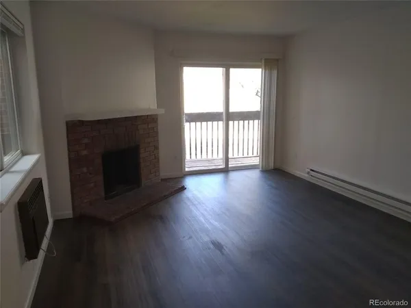 an empty room with wooden floor and fireplace
