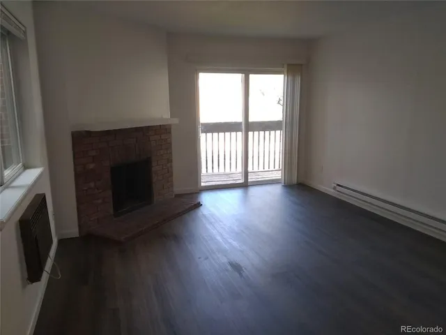 an empty room with wooden floor and fireplace