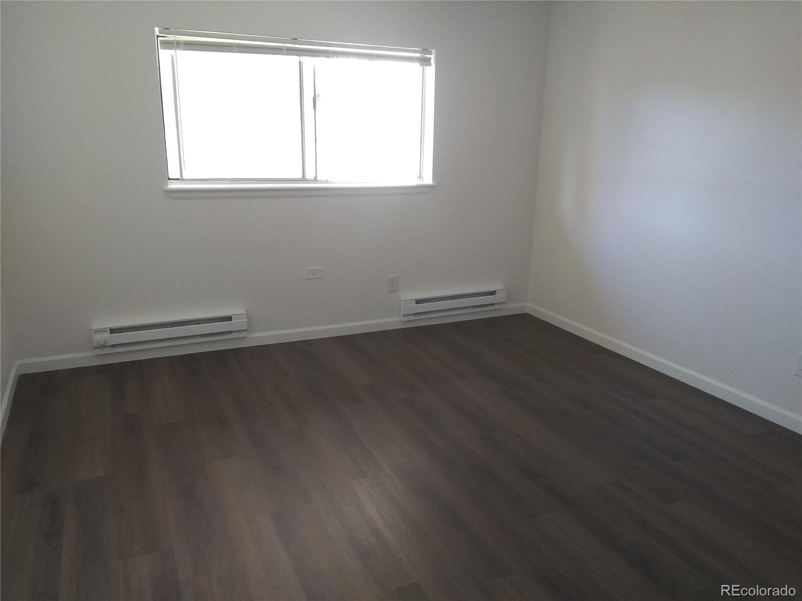 Undisclosed Address Aurora, CO 80011 - Photo 6 of 14 an empty room with wooden floor and windows