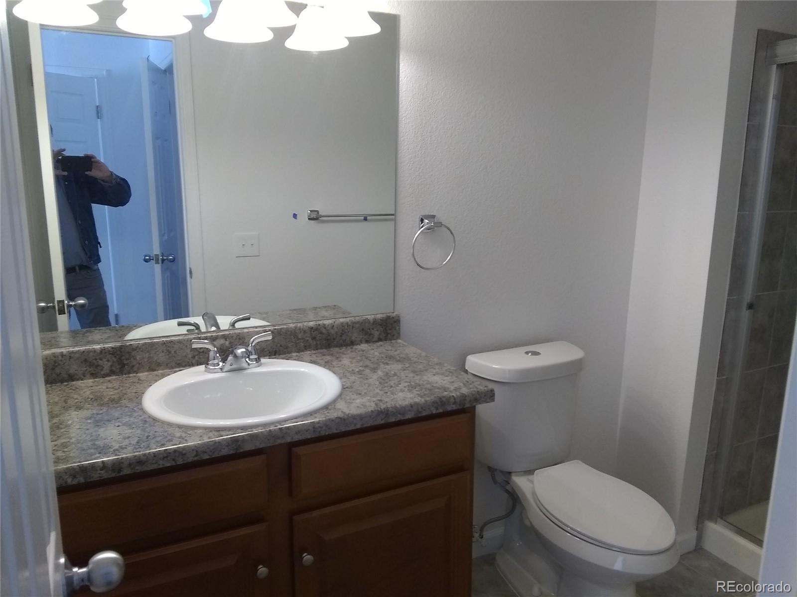 Undisclosed Address Aurora, CO 80011 - Photo 10 of 14 a bathroom with a granite countertop toilet sink and mirror