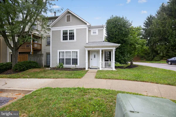 a front view of a house with a yard and trees