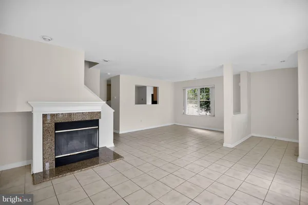 an empty room with windows and fireplace