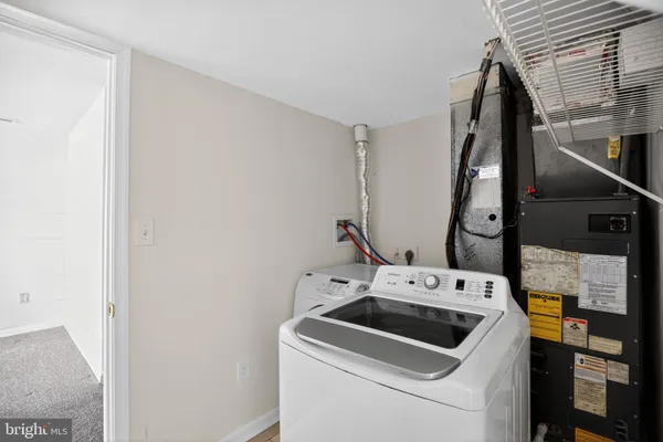 a view of washer and dryer with bathroom in the background