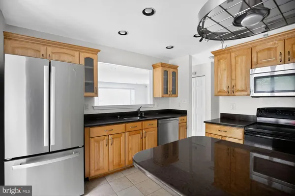 a kitchen with granite countertop a sink stainless steel appliances and cabinets