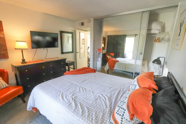a bedroom with a bed and a flat screen tv