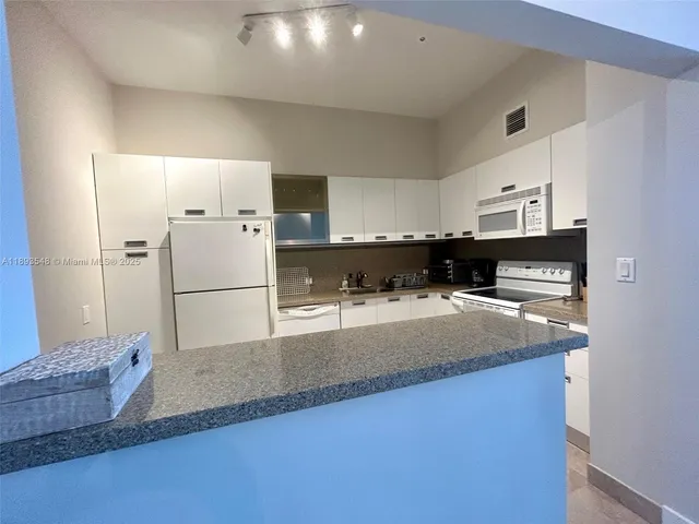 a kitchen with stainless steel appliances a refrigerator sink and stove