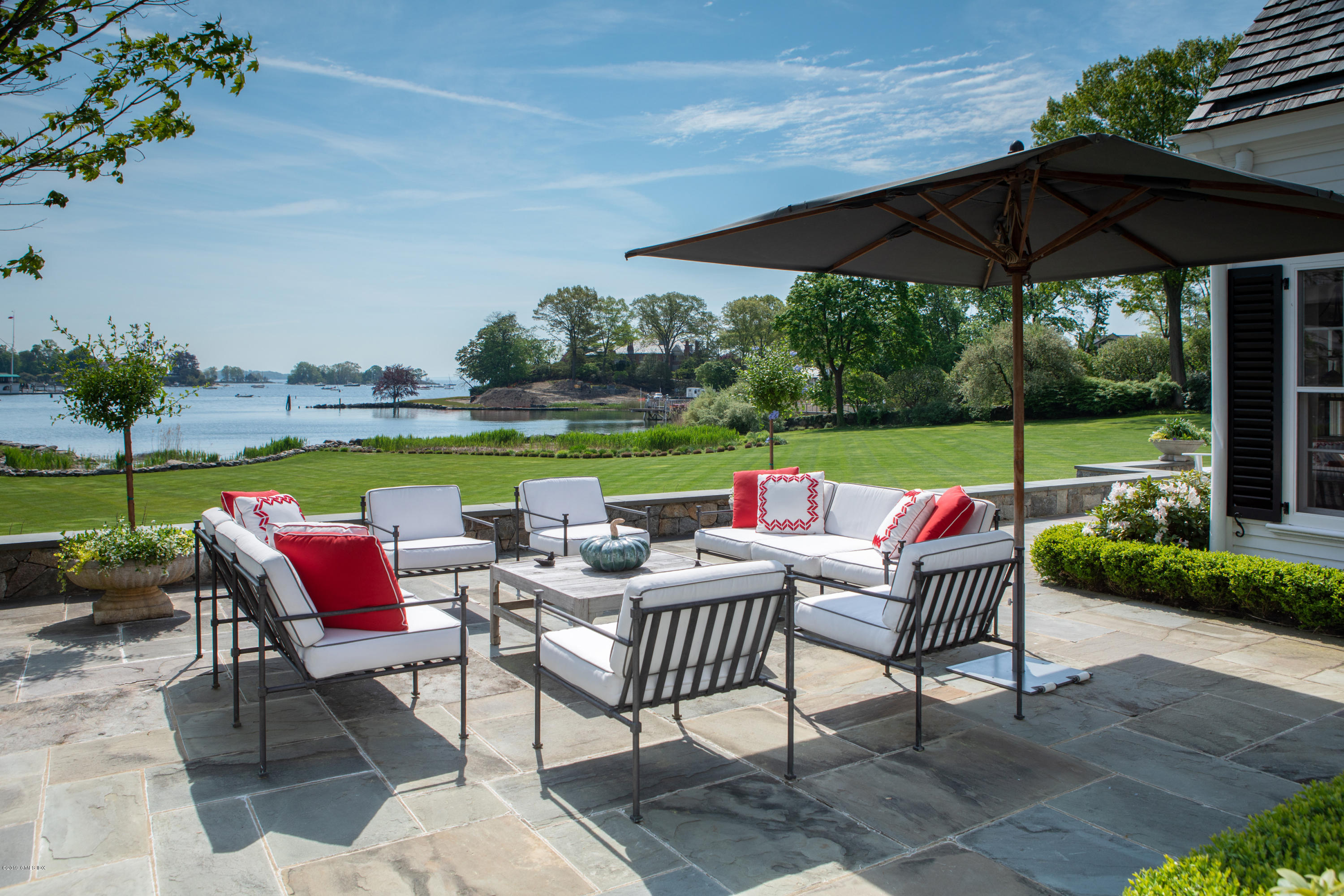 23 Smith Road Greenwich, CT 06830 - Photo 27 of 52 a view of a patio with a table and chairs under an umbrella