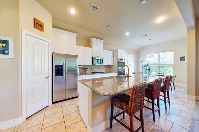 a large kitchen with kitchen island a table and chairs in it