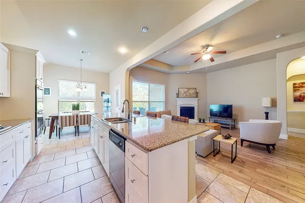 a large kitchen with kitchen island a large counter space a sink appliances and living room view