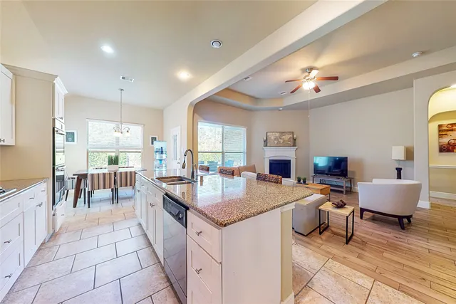 a large kitchen with kitchen island a large counter space a sink appliances and living room view