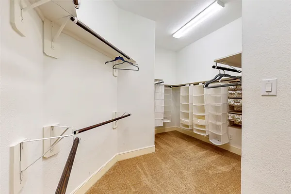 a view of walk in closet with clothes and shoes