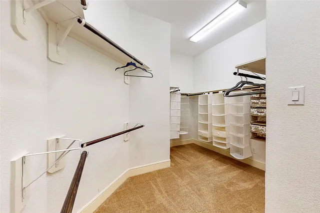 a view of walk in closet with clothes and shoes