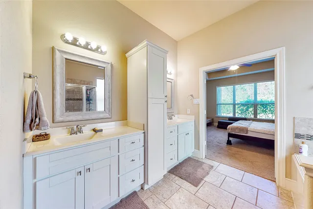 a en suite bathroom with a double vanity sink a large mirror and a shower