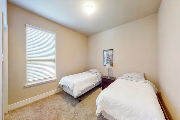 a bedroom with two beds and a window