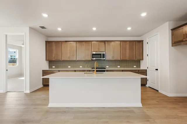 a kitchen with sink stove and wooden floor