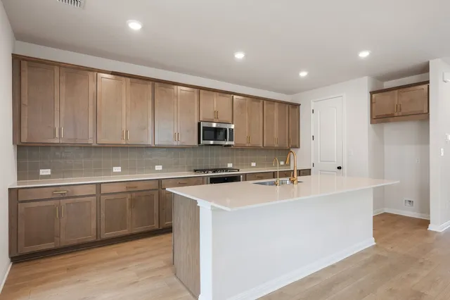 a kitchen with stainless steel appliances granite countertop a sink stove and cabinets