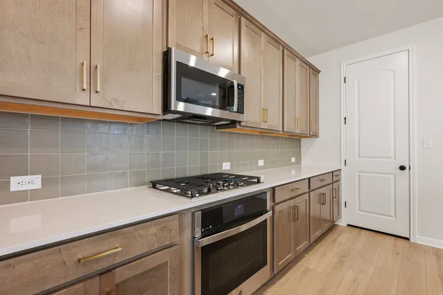 a kitchen with stainless steel appliances granite countertop a sink stove and microwave
