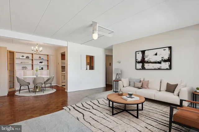 a living room with furniture and a dining table with wooden floor