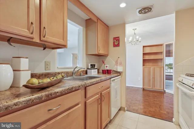 a kitchen with granite countertop a sink a refrigerator and cabinets