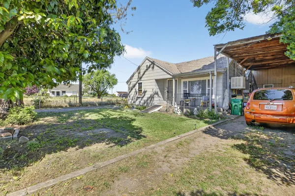 a front view of a house with a yard table and chairs