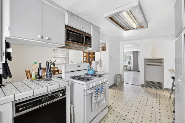 a kitchen with stainless steel appliances a stove a sink and a refrigerator
