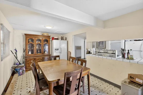 a dining hall with stainless steel appliances granite countertop a dining table and chairs with wooden floor