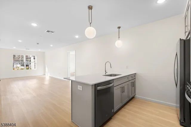 a view of a kitchen with a sink and wooden floor