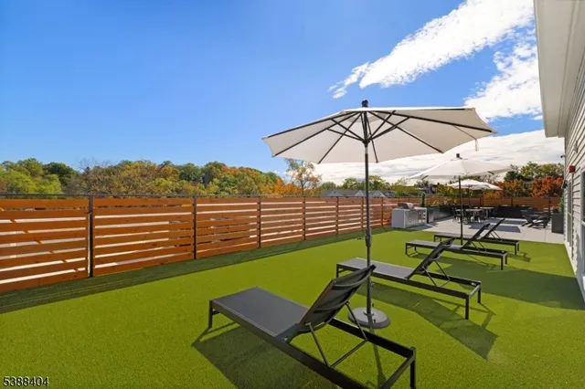 a view of a tennis ground with a table and chairs