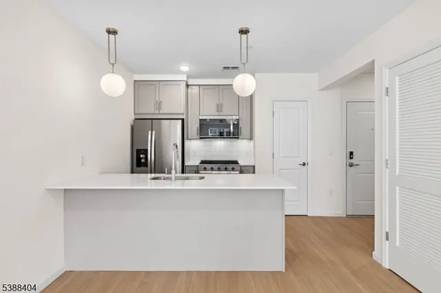 a view of a kitchen with cabinets and stainless steel appliances