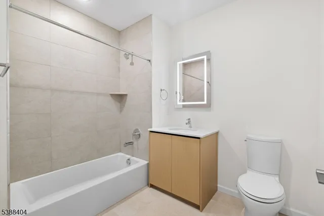 a bathroom with a toilet a sink a mirror and bathtub