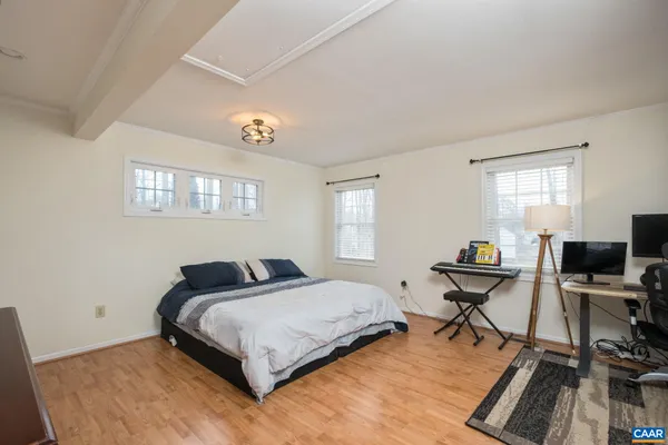 a bedroom with a bed and wooden floor