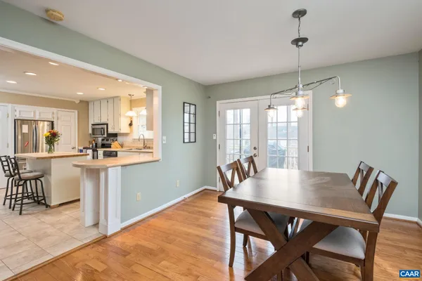 a view of a dining room and livingroom with furniture wooden floor a chandelier