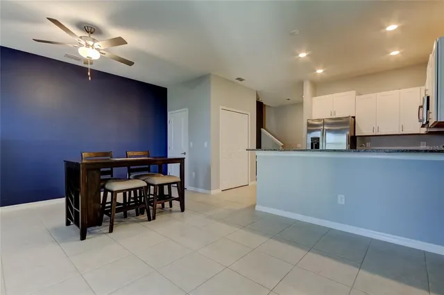 a kitchen with stainless steel appliances a dining table chairs and stove
