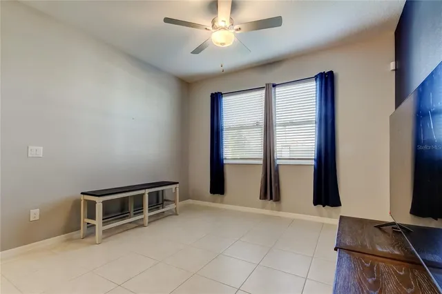 an empty room with windows and ceiling fan