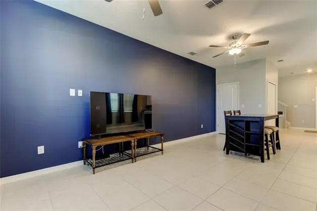 a view of a room with a ceiling fan and a window