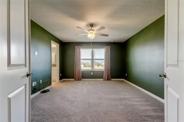 an empty room with chandelier fan