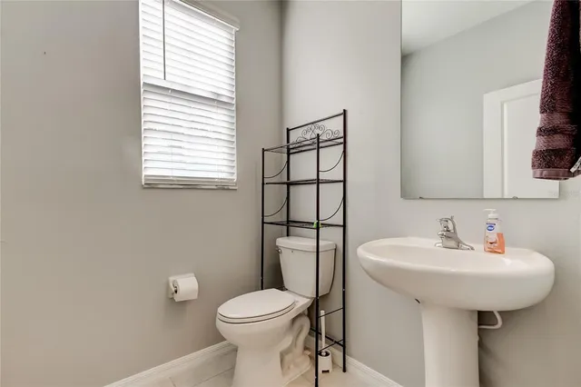 a bathroom with a sink toilet and mirror
